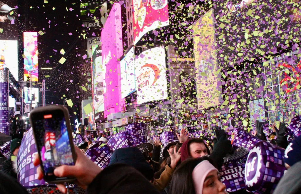 People from all over the world are seen gathered for the 2026 Ball Drop at Times Square amid cold weather.