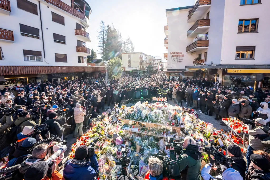 People gather around a makeshift memorial in the middle of Crans Montana days after the deadly blaze. 
