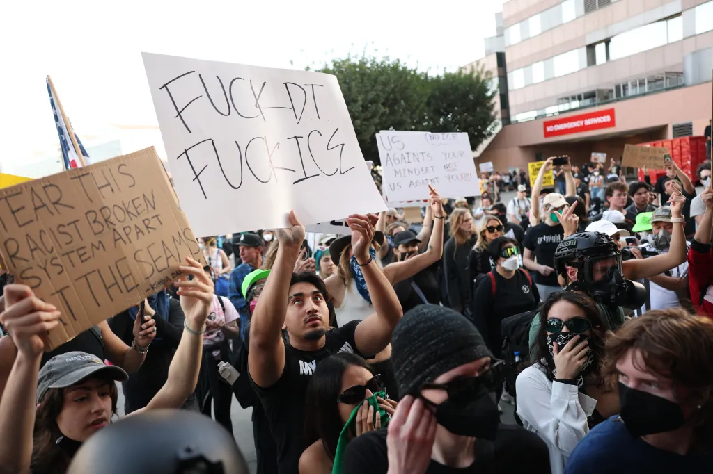 People protest against US Immigration and Customs Enforcement, holding signs that read