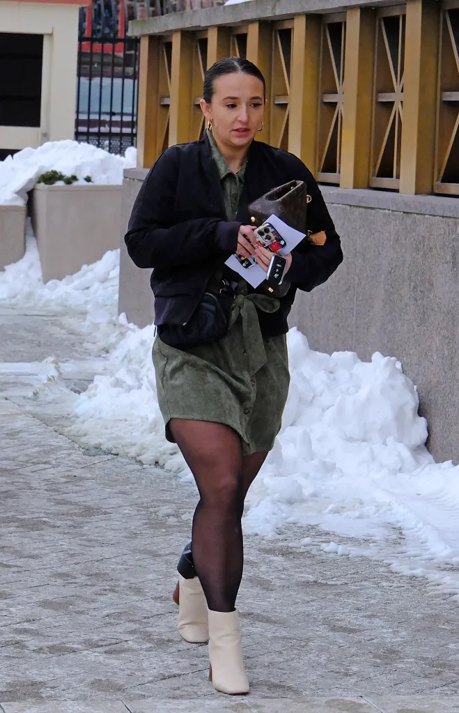 Natalie Greene walking in the snow with an ankle monitor visible above her left boot.