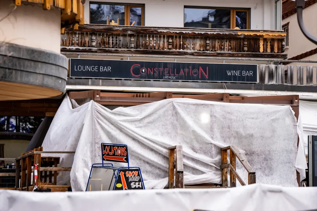 The entrance of Le Constellation bar covered with white tarps and wooden barriers, with a sign for 