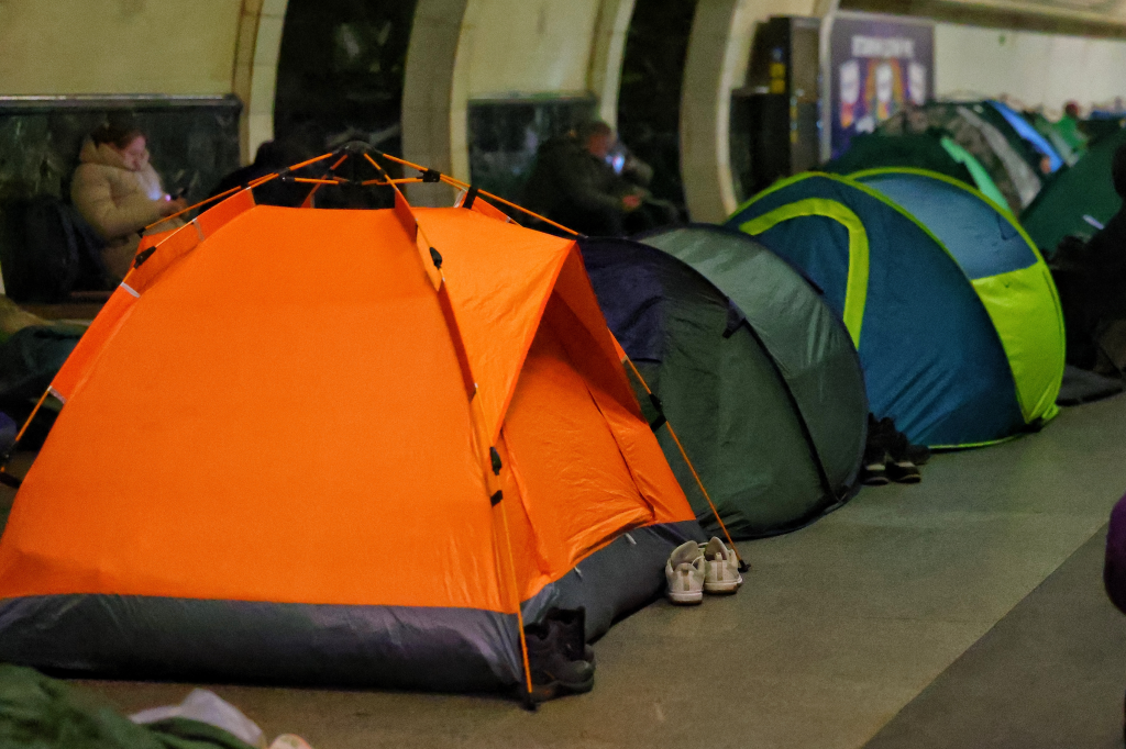 People sleep in tents inside a subway station used as shelter during a Russian drone strike.