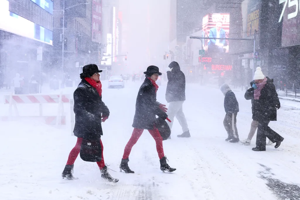People walking across Sixth Avenue in Manhattan during the snow storm.