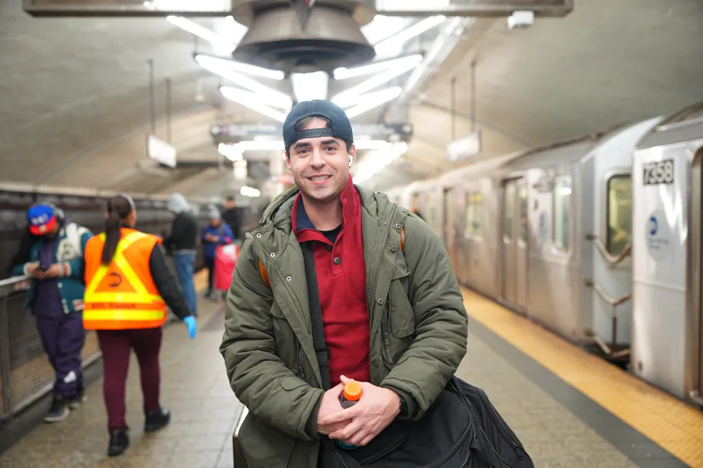 Mayan Crampton smiles at the camera on a subway platform.