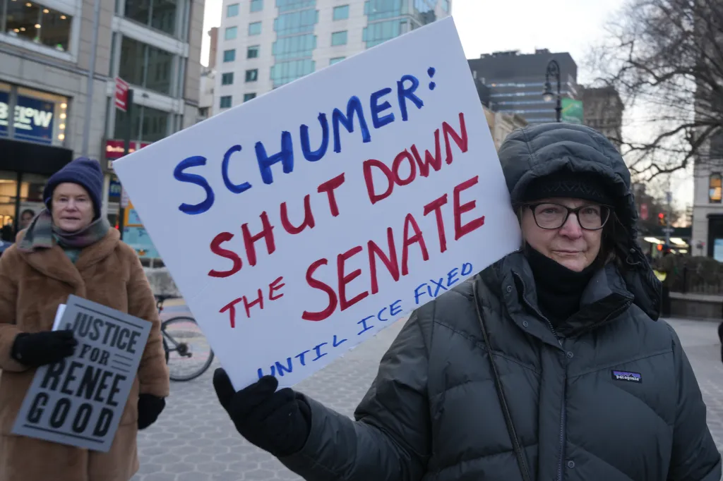 A protester holds a sign calling for Sen. Schumer to shut down the senate during a protest in New York City on Jan. 24, 2026.