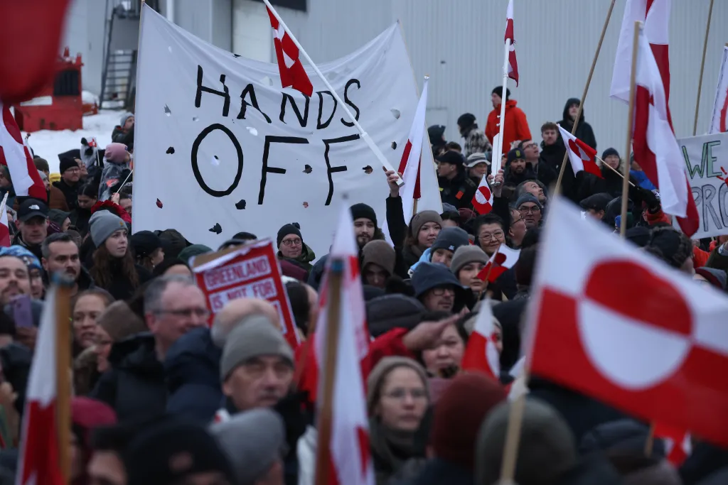People hold up a banner that reads 