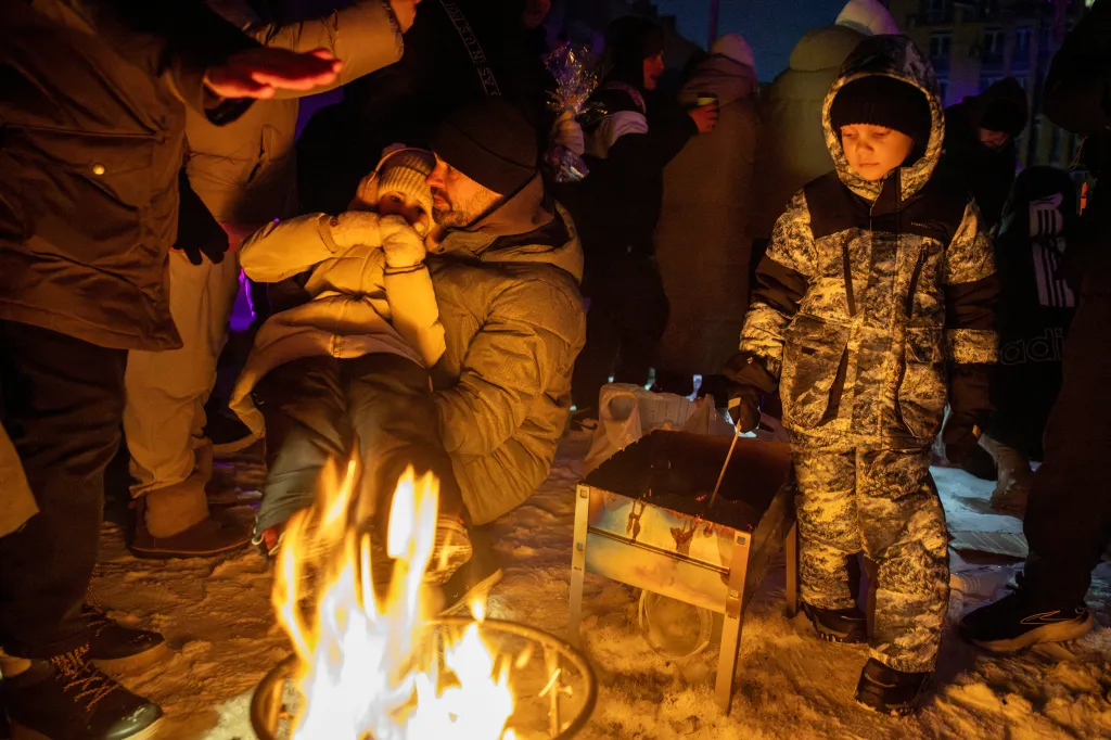 Ukrainians warm themselves at a bonfire after a Russian airstrike knocked out electricity in their neighborhood on Jan. 24, 2026.