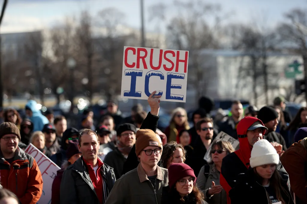 One demonstrator holds up a sign saying, 