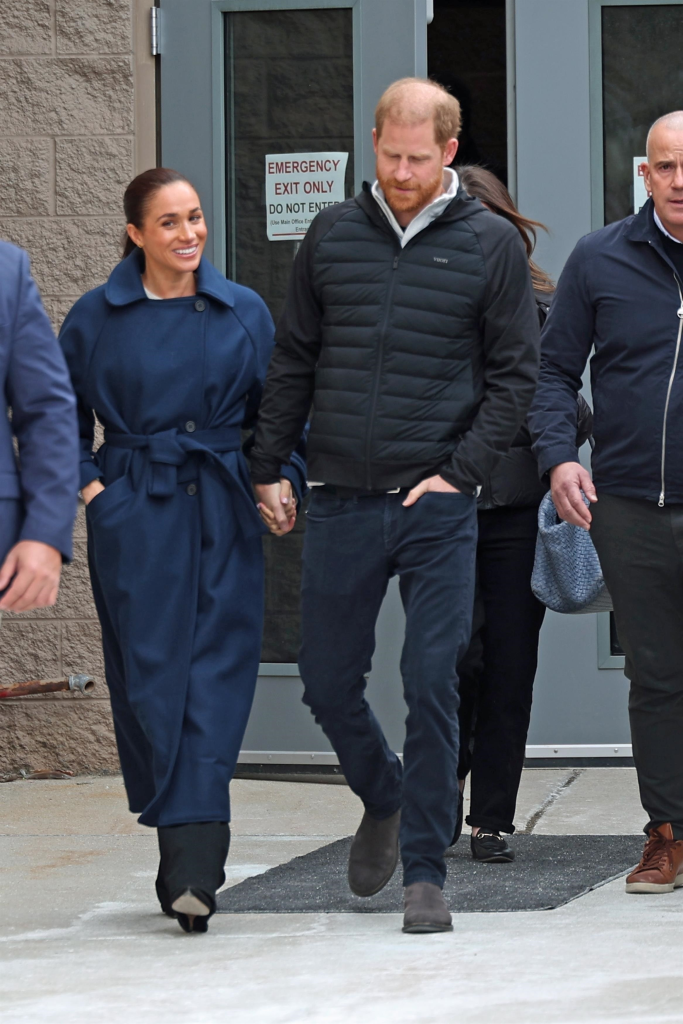 Meghan Markle and Prince Harry holding hands while attending the