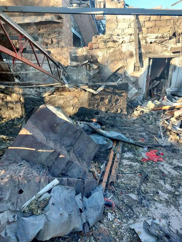 The interior of a building shows debris and structural damage from a drone attack.
