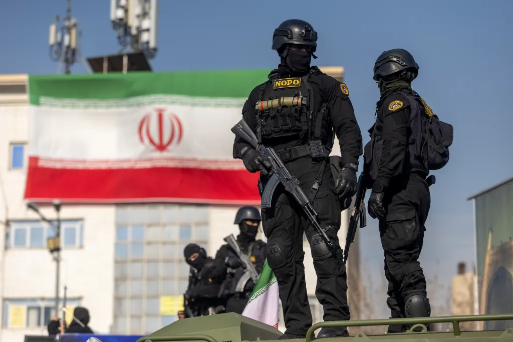Iranian security forces standing in front of the Iranian flag.