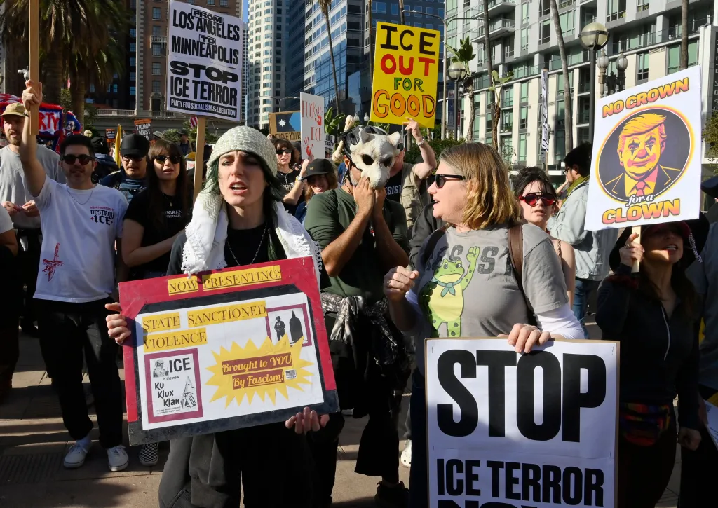 Activists protest federal officer-involved shootings in Los Angeles, holding signs that read 