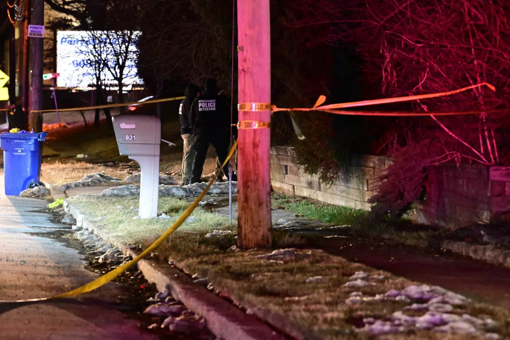 Piscataway police detectives at a crime scene with caution tape.