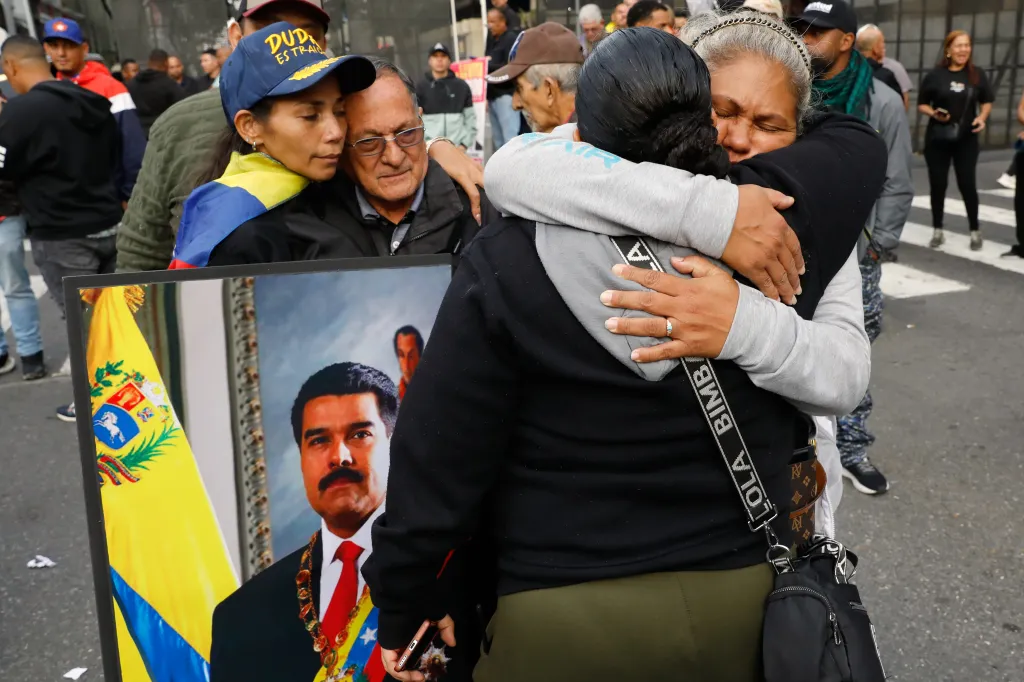 Supporters of Venezuelan President Nicolas Maduro embrace and comfort each other in Caracas.