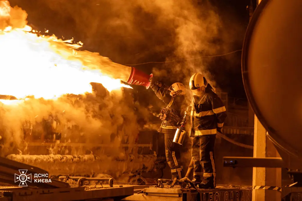 Ukrainian rescuers work to extinguish a burning petrol truck following an air attack in Kyiv on January 24, 2026.