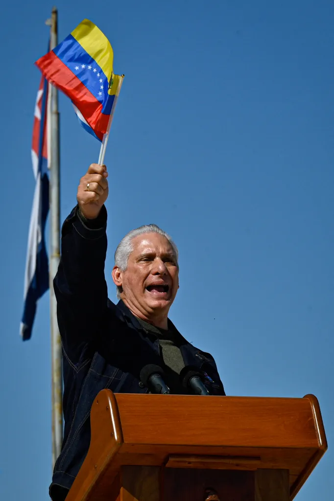 Cuba's President Miguel Diaz-Canel delivers a speech, fluttering a Venezuelan national flag.