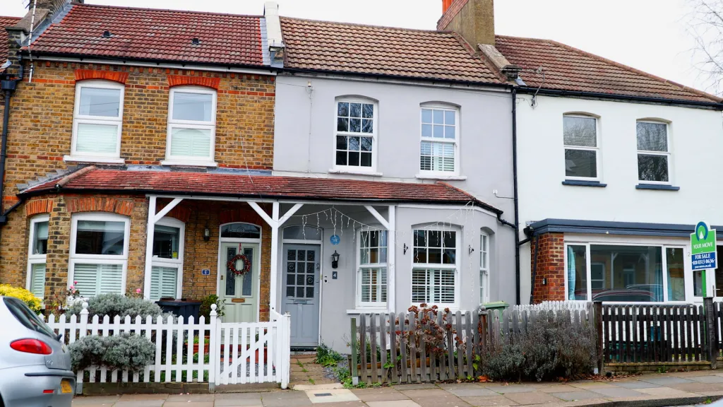 The childhood home of musician David Bowie in Bromley, England, featuring three attached houses with differing exterior colors and fences.