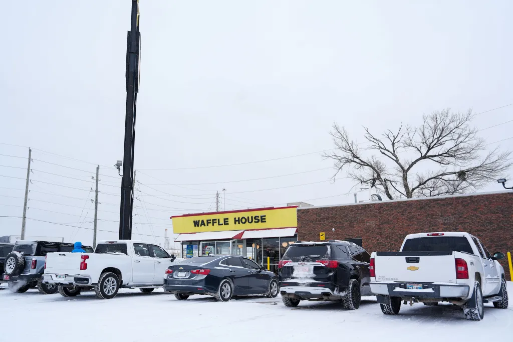 Cars sit in a snow-covered parking lot outside a Waffle House in Tulsa, Oklahoma, on Jan. 24, 2026. 
