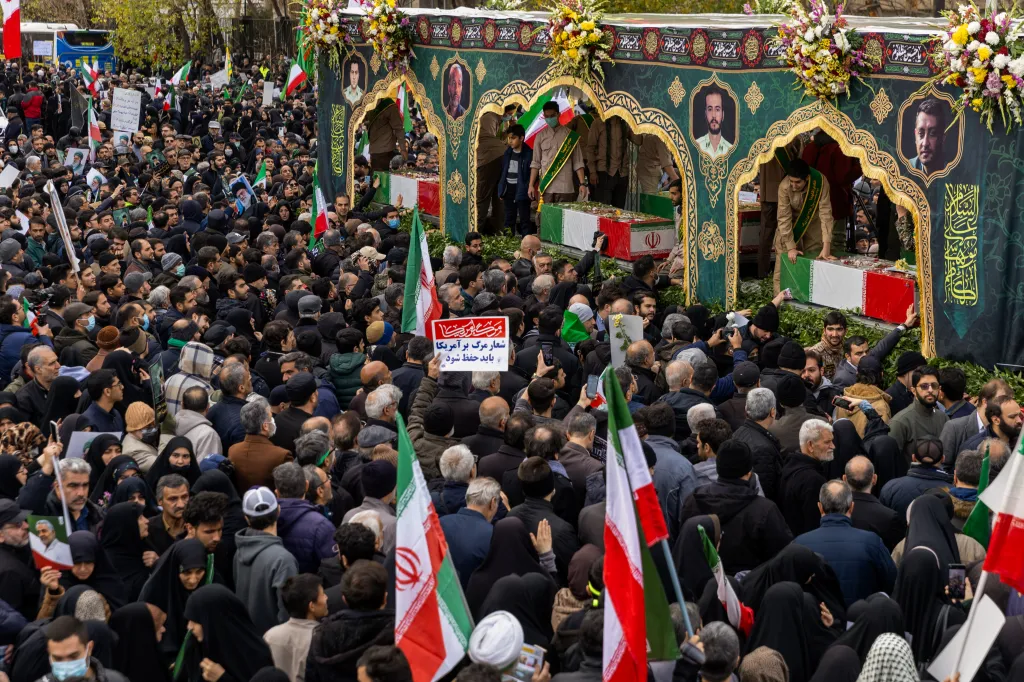 A crowd watches as the caskets of members of Iran's security forces, whom authorities said were killed during recent nationwide protests, are transported during a mass funeral on January 14, 2026 outside Tehran University in Tehran, Iran.