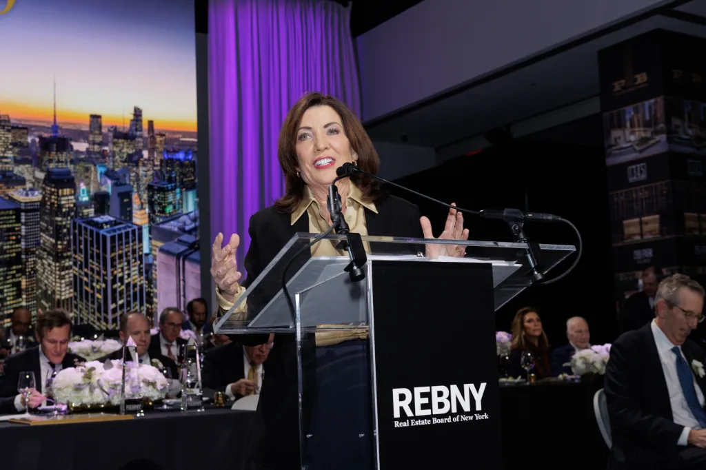 A woman speaking at a podium with the 