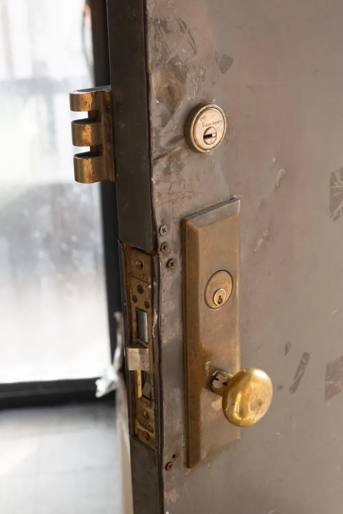 Damaged front door with multiple locks on Mordistine Alexander's apartment at 1520 Sedgwick Ave., Bronx, NY.
