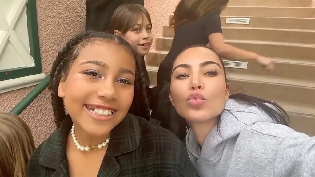 North West smiling next to Kim Kardashian pouting her lips.