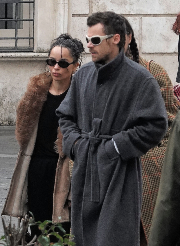 Harry Styles in a charcoal wool wrap coat and Zoë Kravitz in a brown faux fur shearling-style jacket.