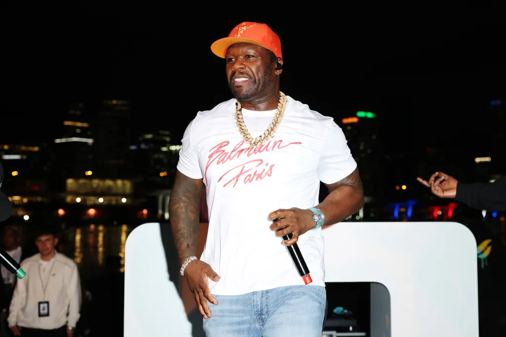 50 Cent performing with a microphone at an event in Miami, Florida.