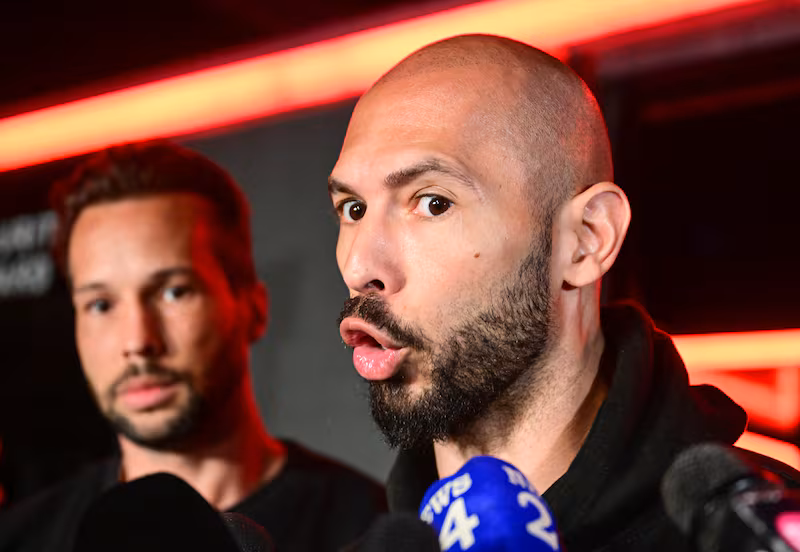 Andrew Tate (R) and his brother Tristan (L) speak to the media as they arrive in Romania back from US.