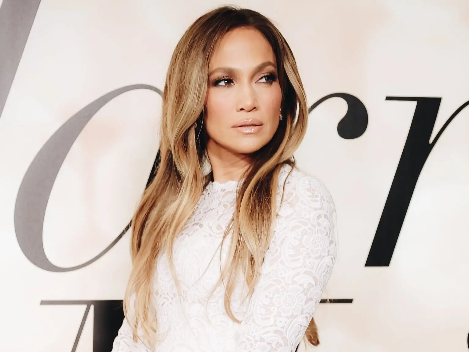 Jennifer Lopez in a short, white, lace bridal gown at the premiere of