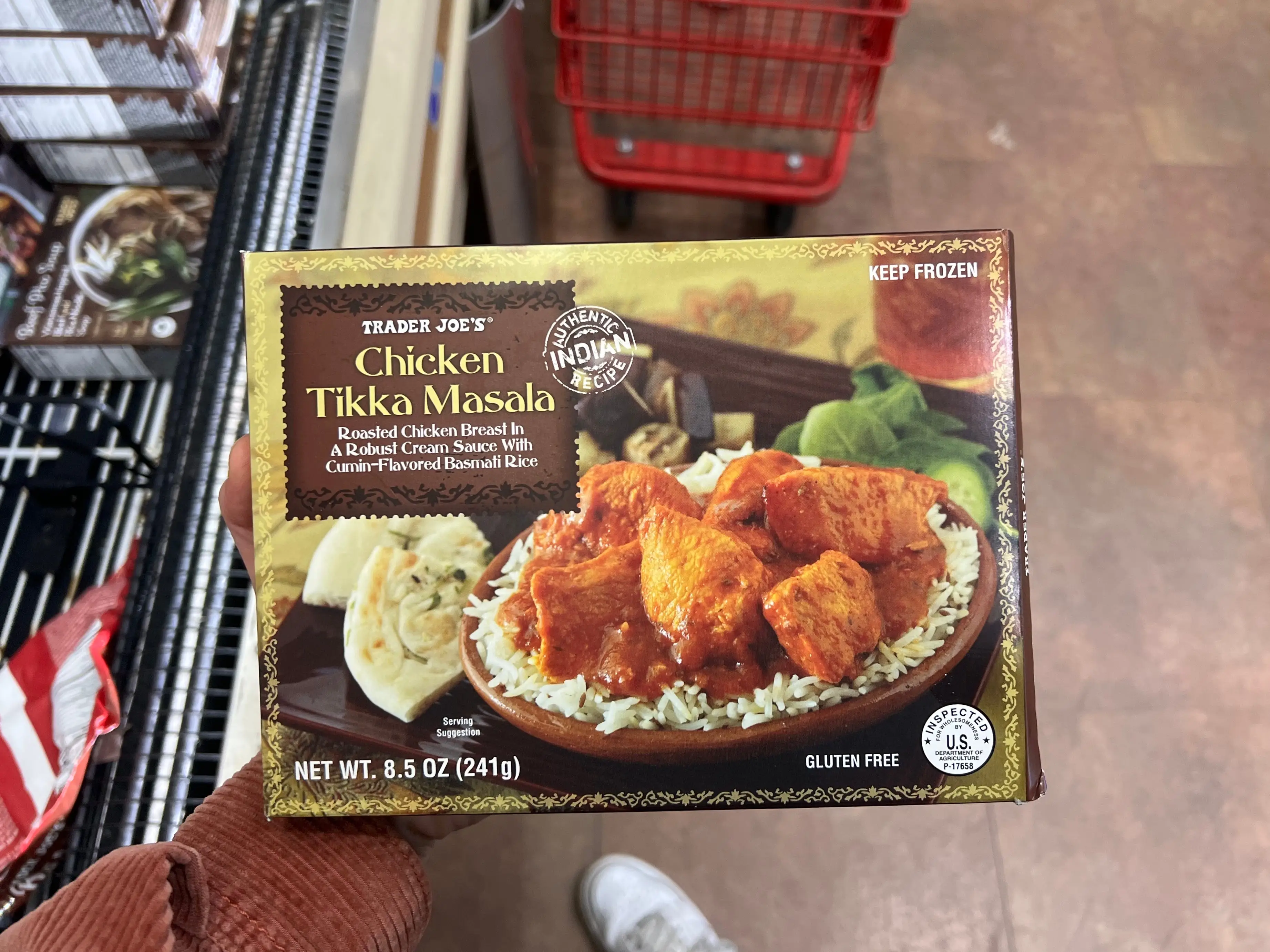 The writer holds a box of Trader Joe's chicken tikka masala