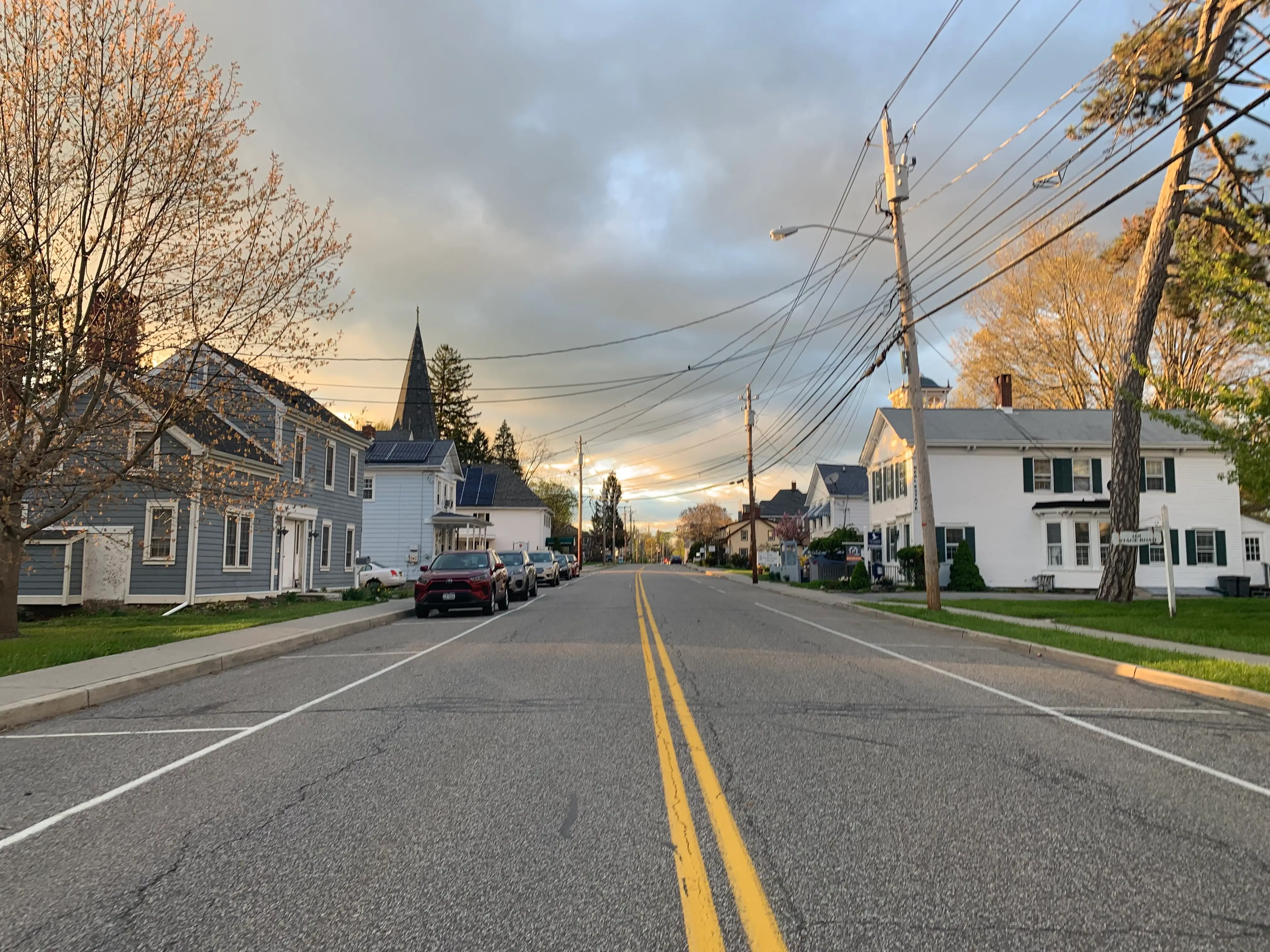 A view down a street with houses and cars either side.