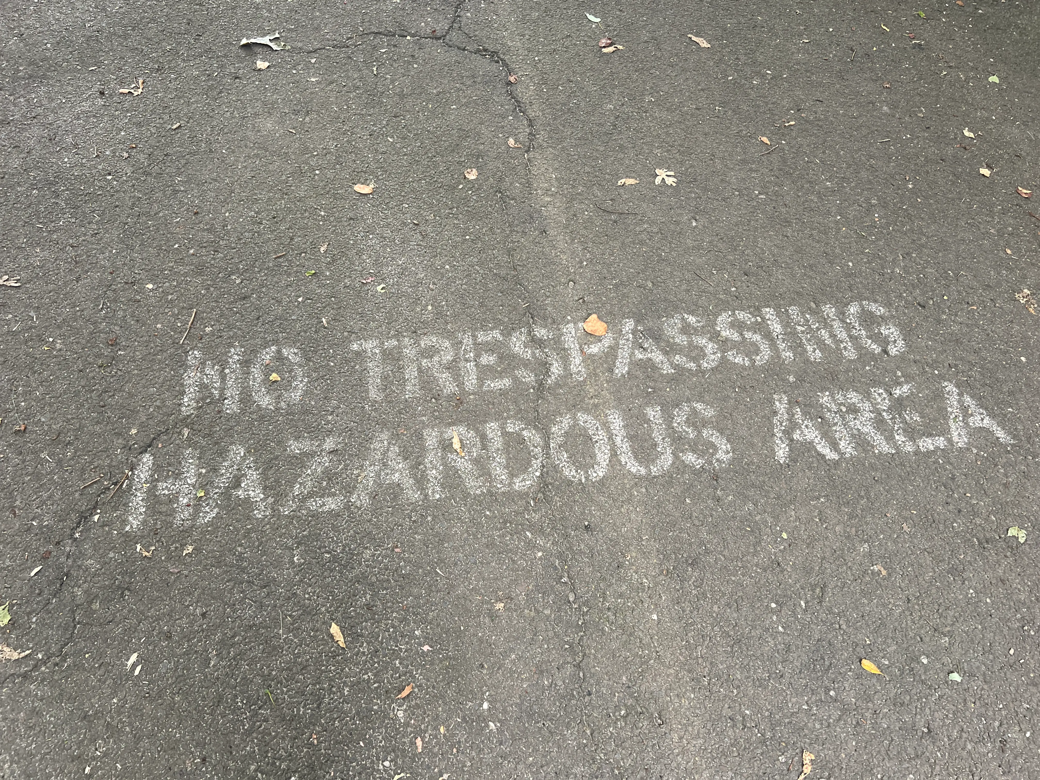 a sign on the ground that says no trespassing hazardous area