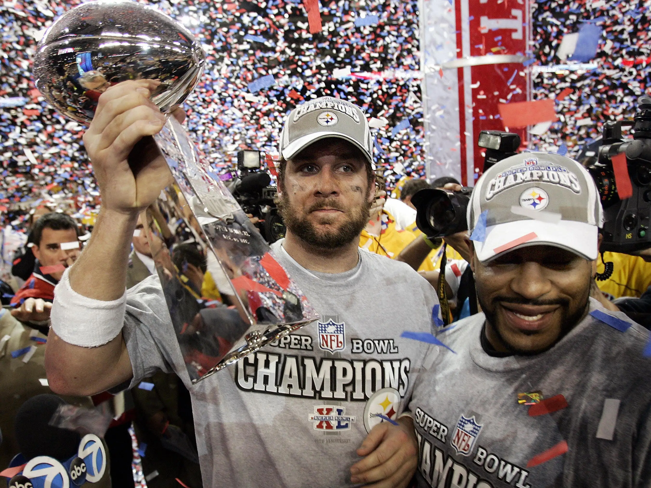 Pittsburgh Steelers quarterback Ben Roethlisberger holds the Vince Lombardi trophy with teammate Jerome Bettis to his right as confetti falls around them.