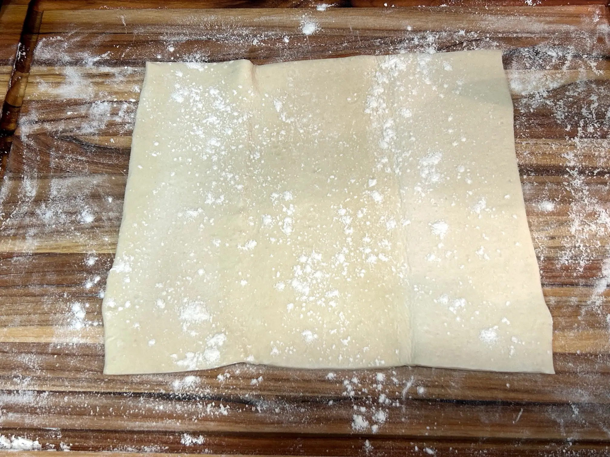 Rolling out puff pastry for croutons in Ina Garten's chicken pot pie soup