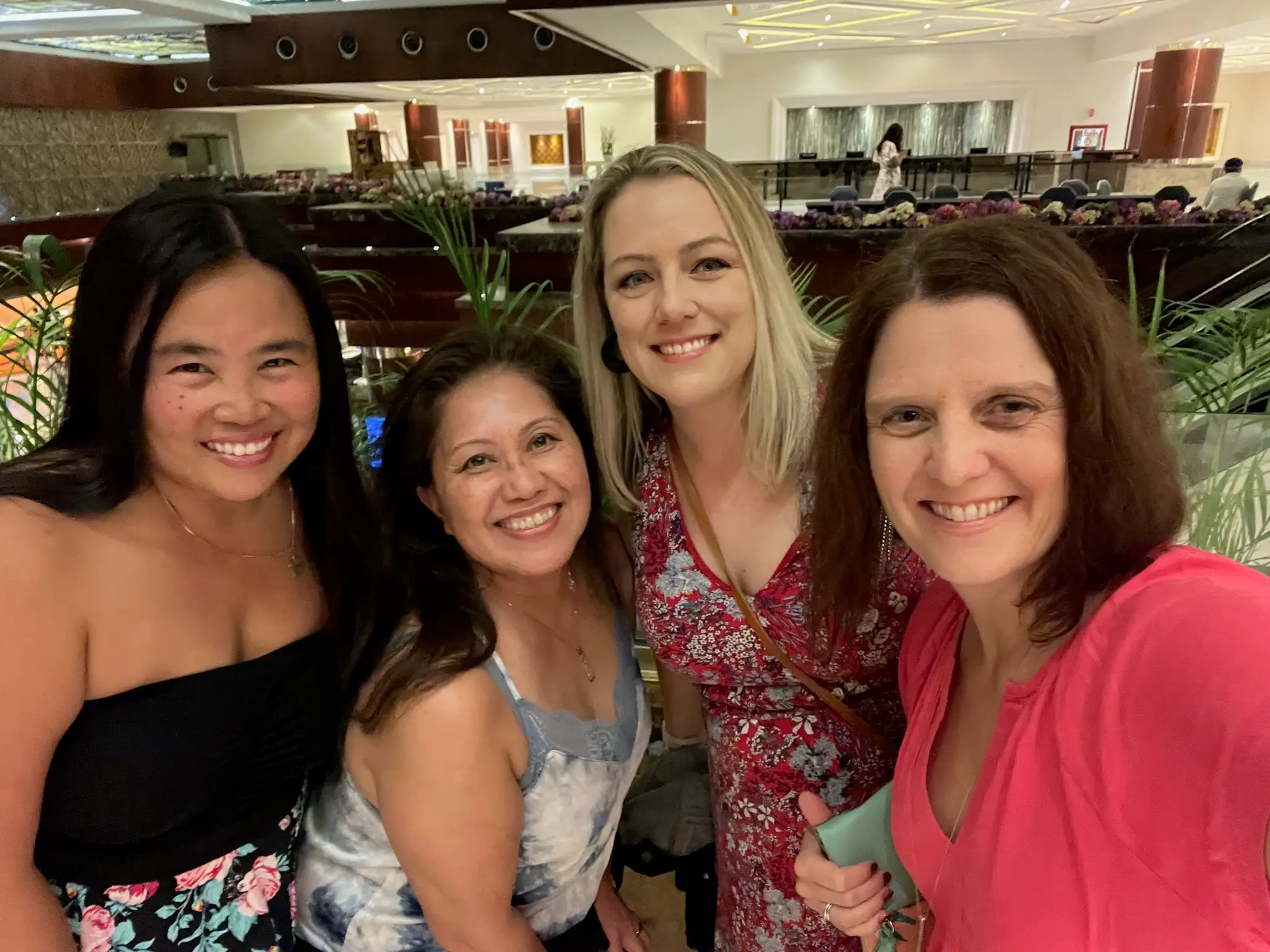 kari posing for a selfie with a group of women in a lobby of an all-inclusive resort