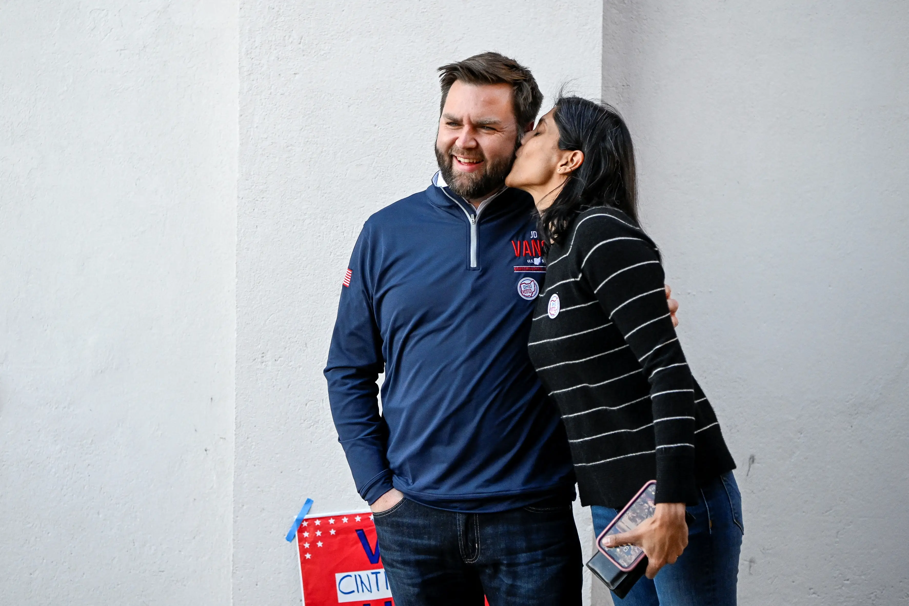 Usha Vance kisses her husband, JD Vance, on the cheek.