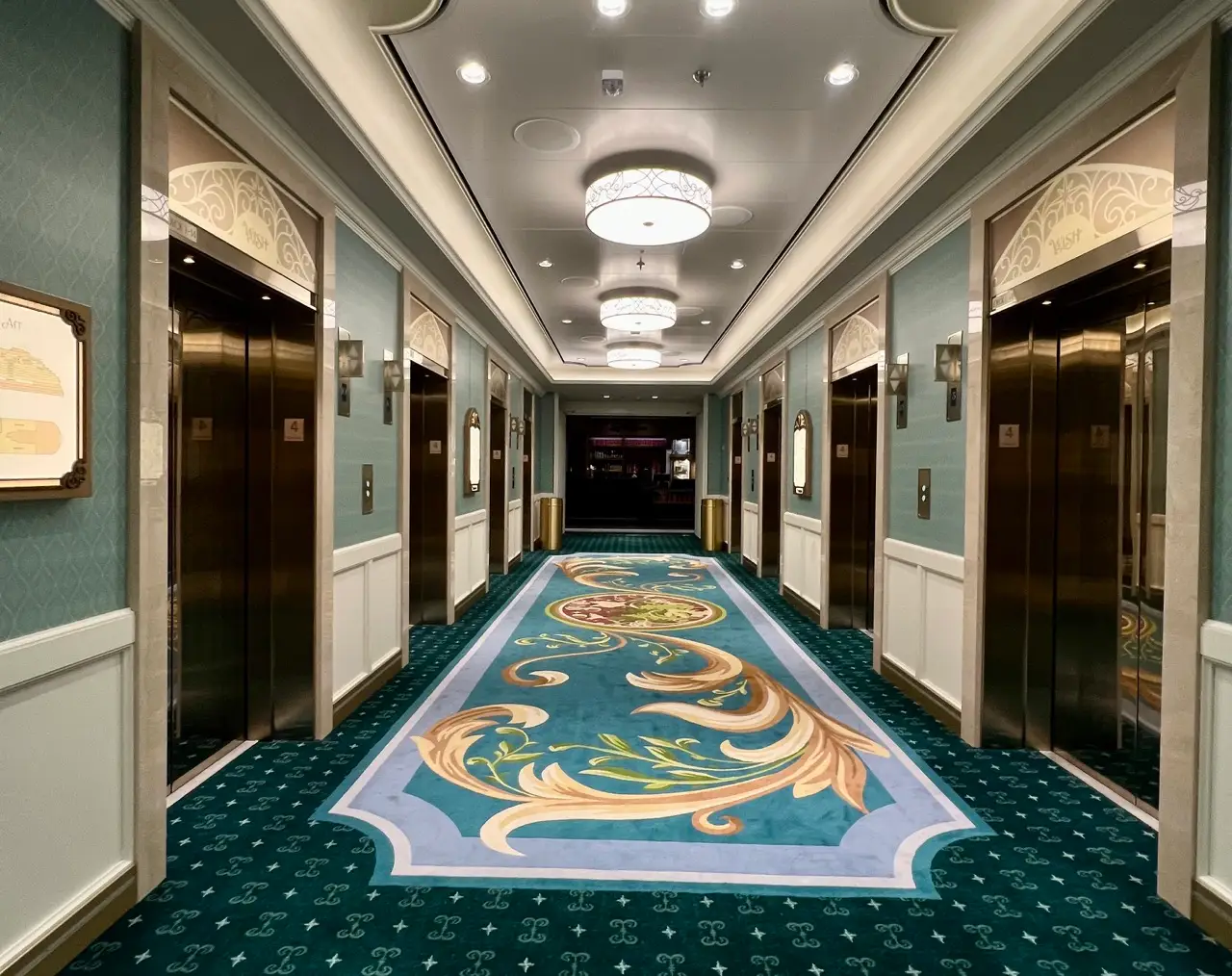 Elevator doors on a cruise ship, with ornate carpet in the hallway.