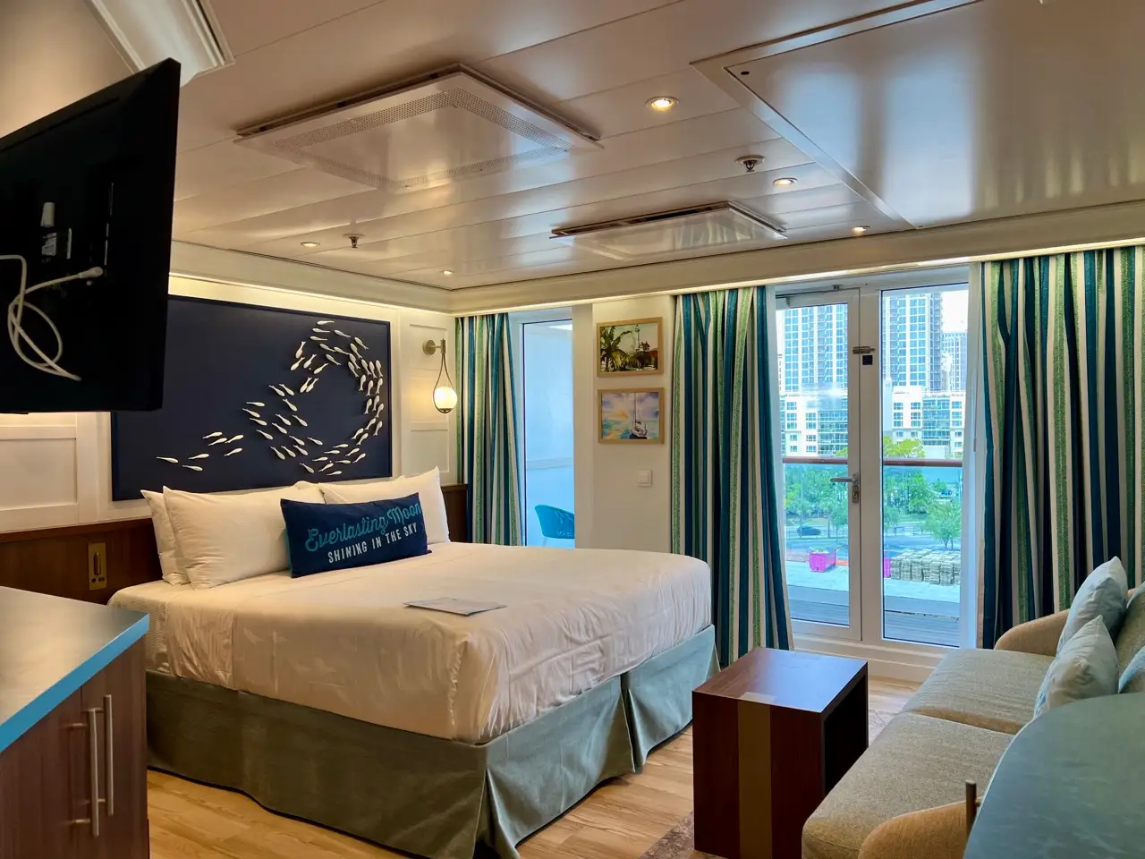A stateroom on a cruise ship with a terrace.