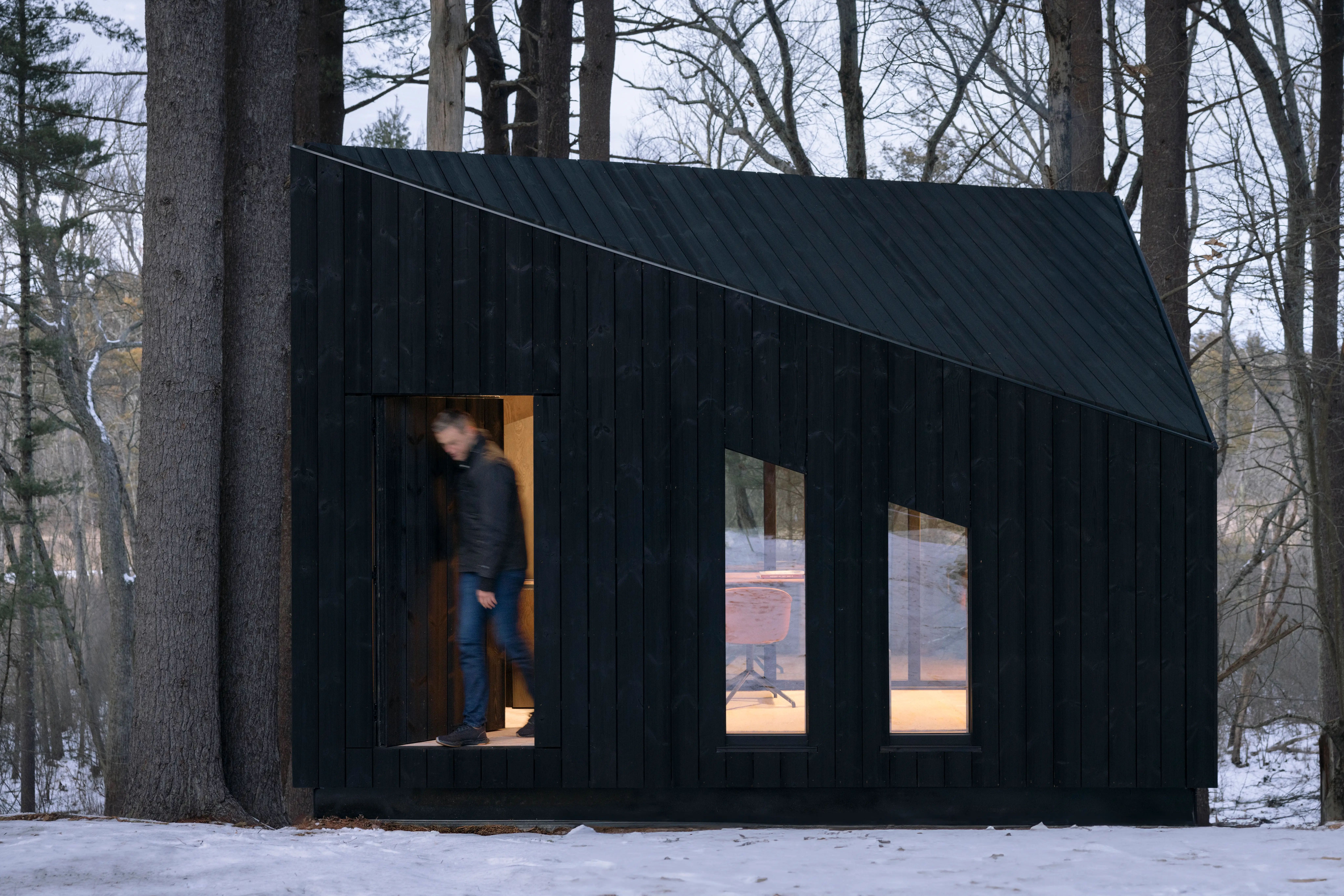 A medium-sized NIWA cabin made by Koto Studio, with aman exiting it.