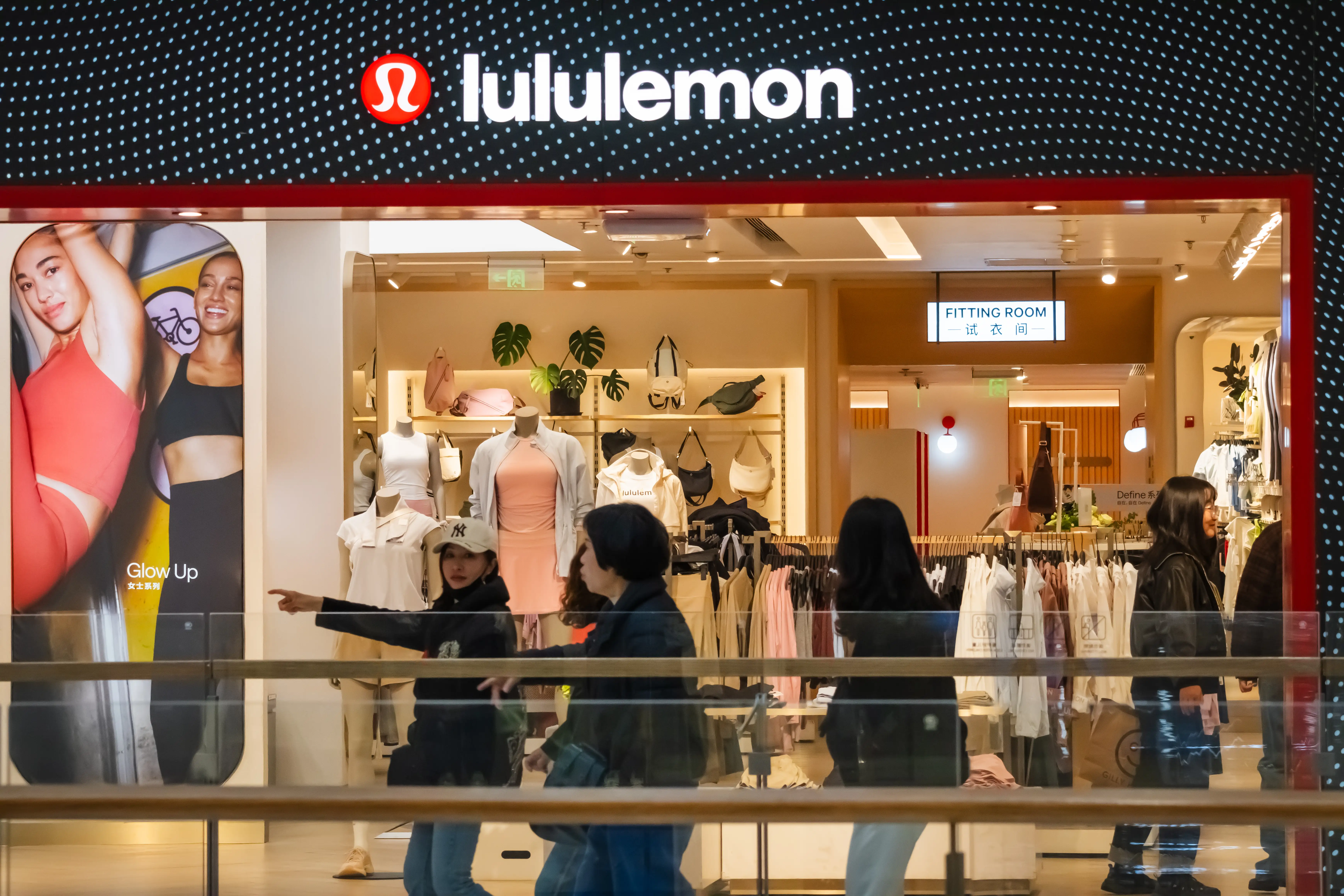 Shoppers walk past a Lululemon store.