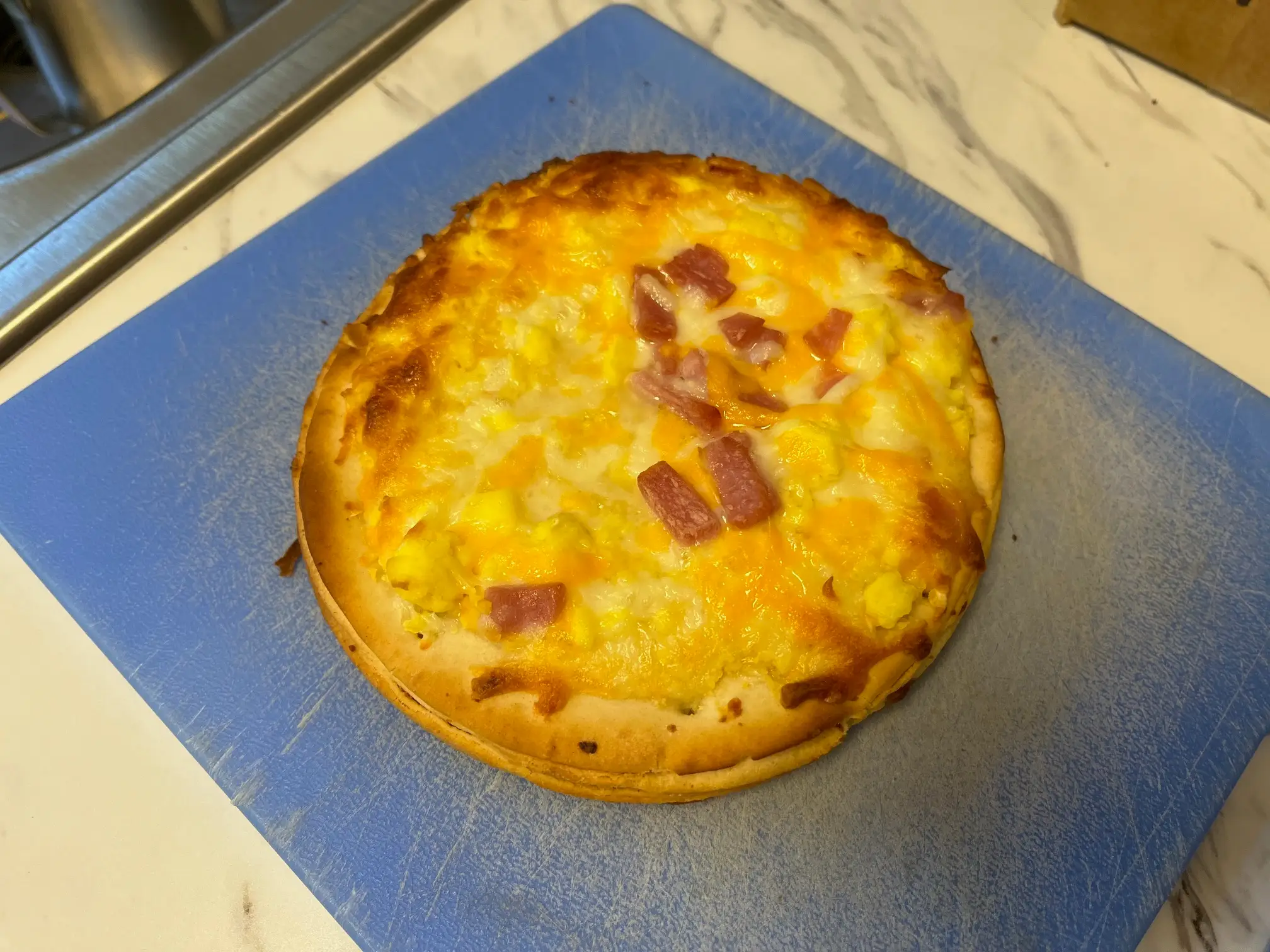 A DiGiorno croissant from Grocery Outlet sits on a cutting board after being heated up in an oven.