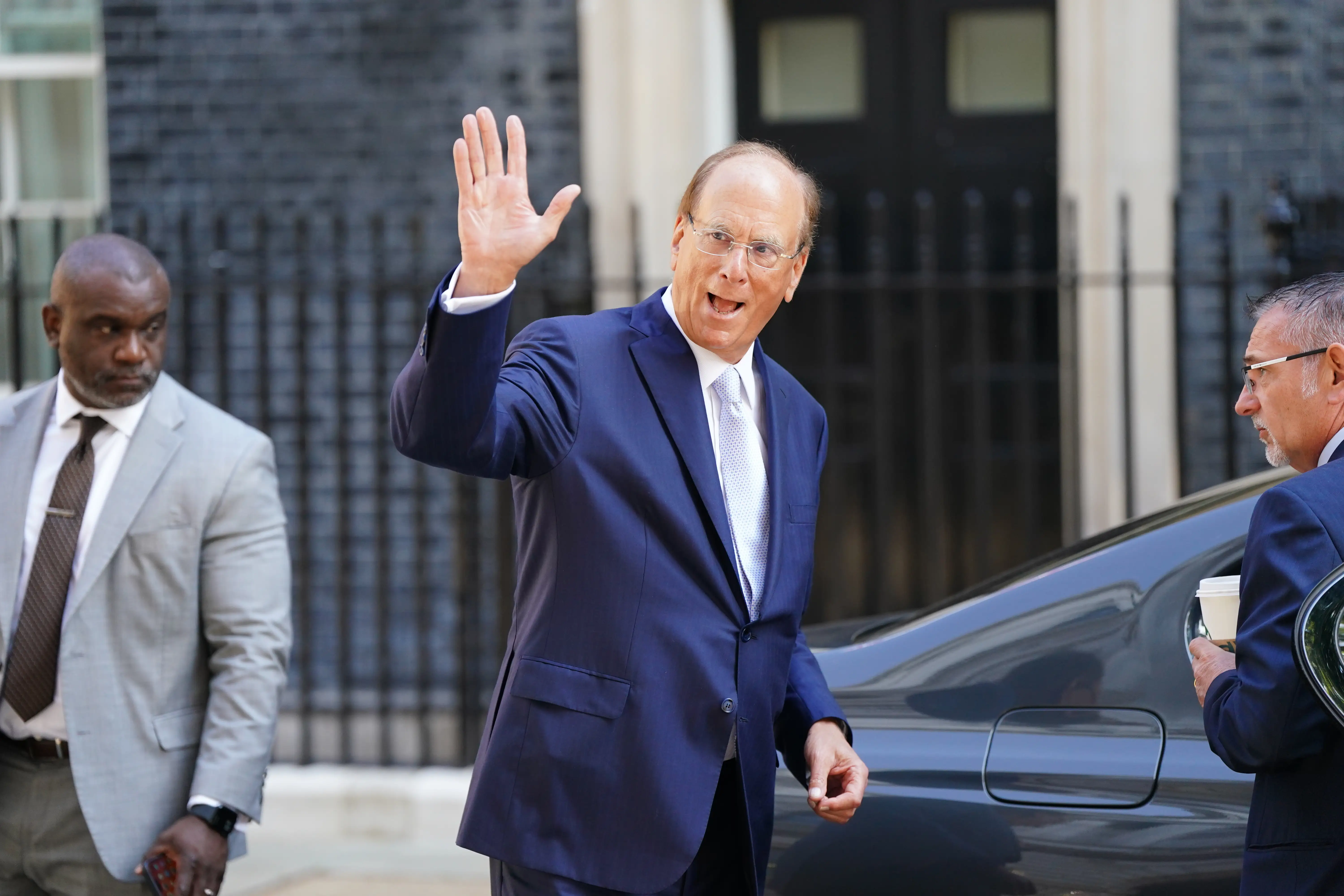 Larry Fink waves near Downing Street