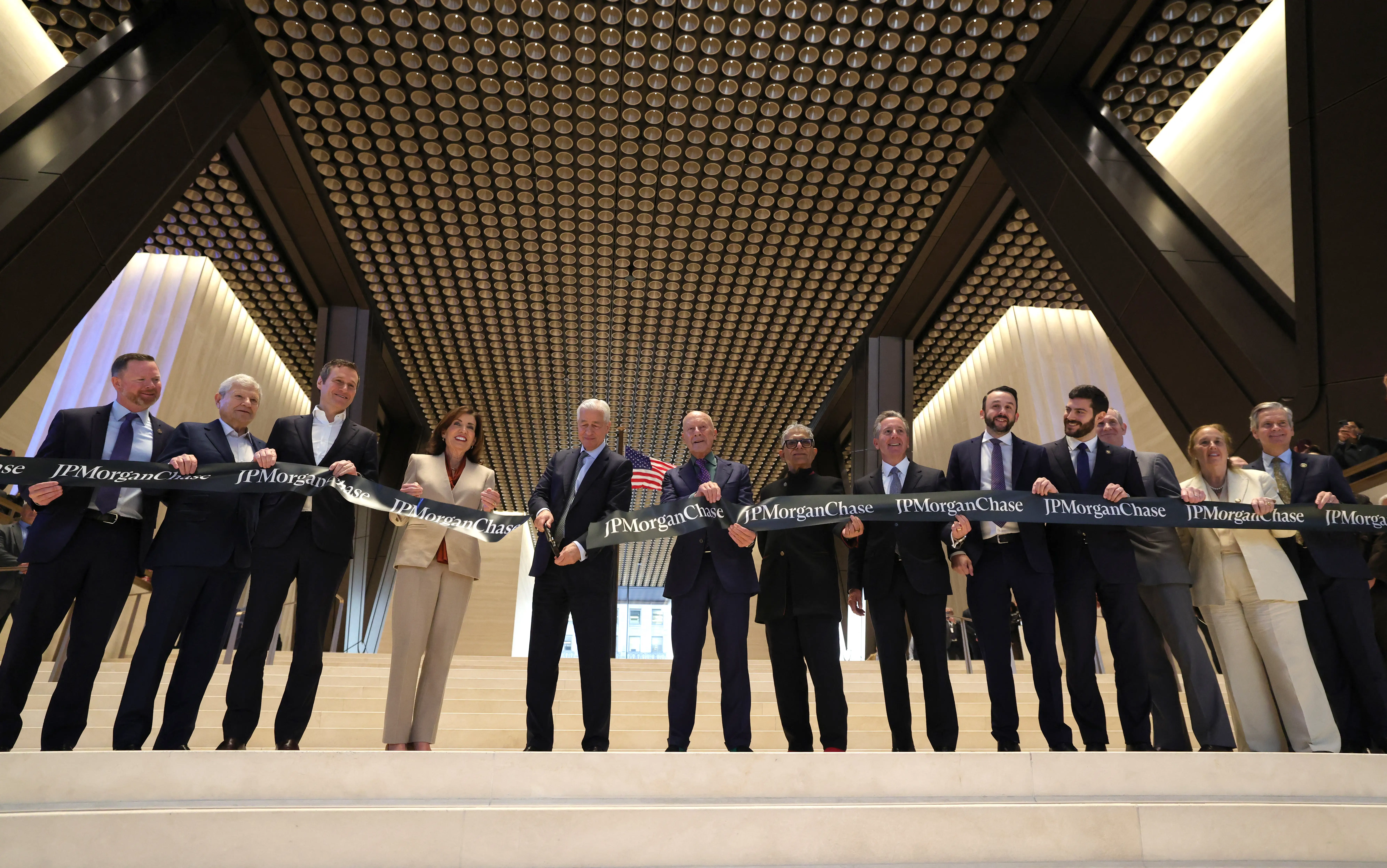 Jamie Dimon stands alongside New York Governor Kathy Hochul and others as he cuts a ribbon to mark the opening of the new JPMorgan Chase global headquarters at 270 Park Avenue.