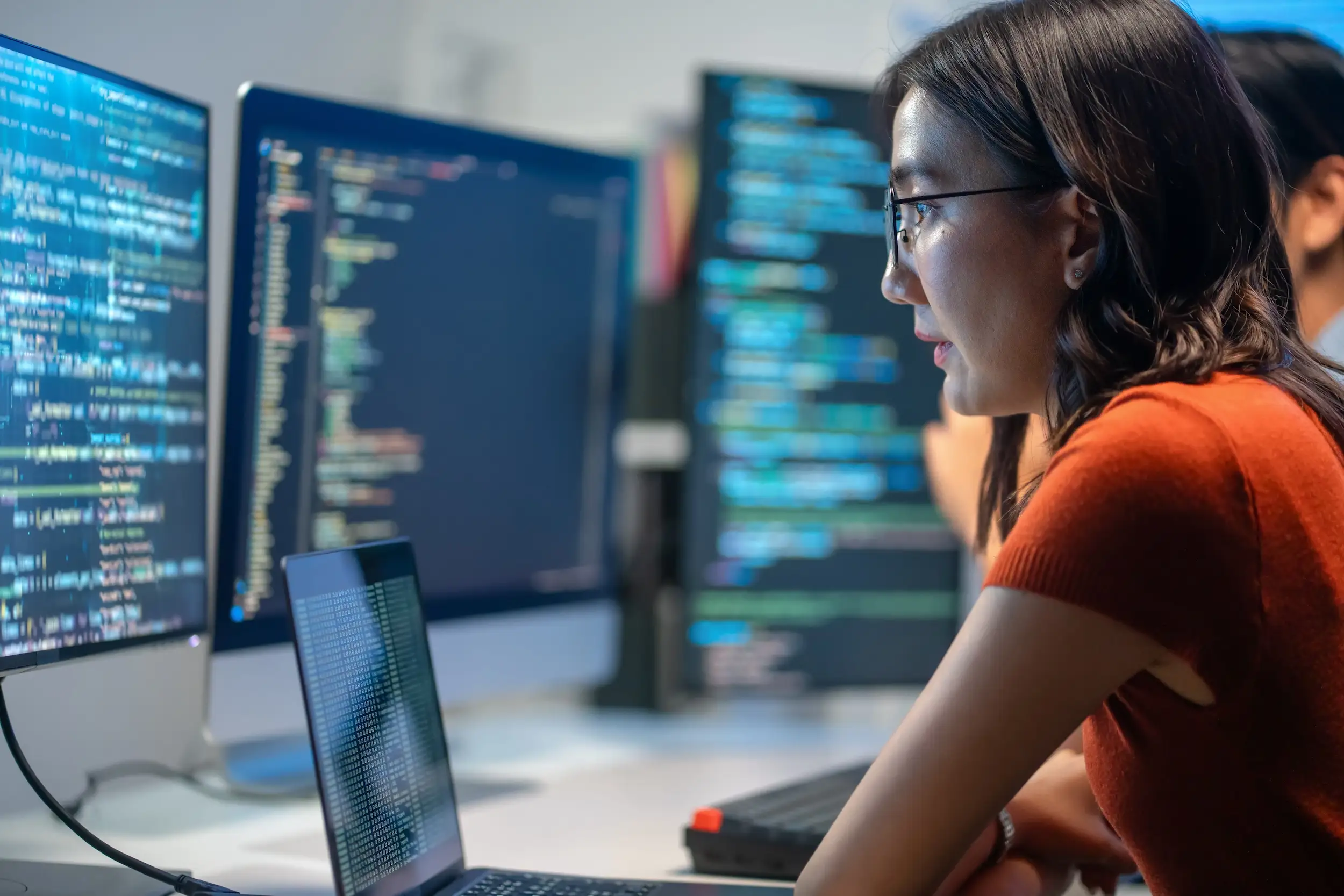 A stock image of someone looking at a computer screen of code