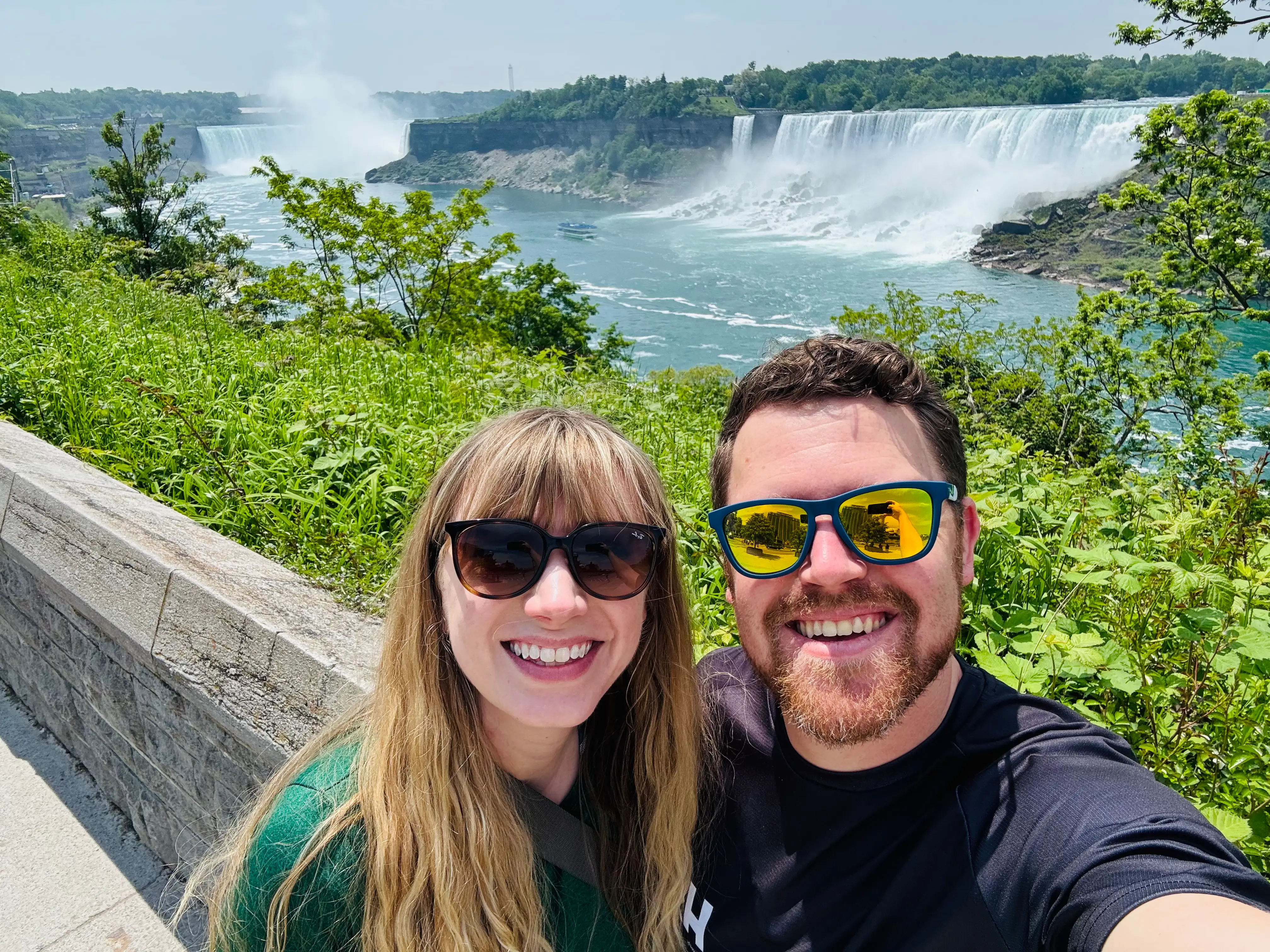 Emily and her husband take a selfie in front of a waterfall in Niagara Falls.