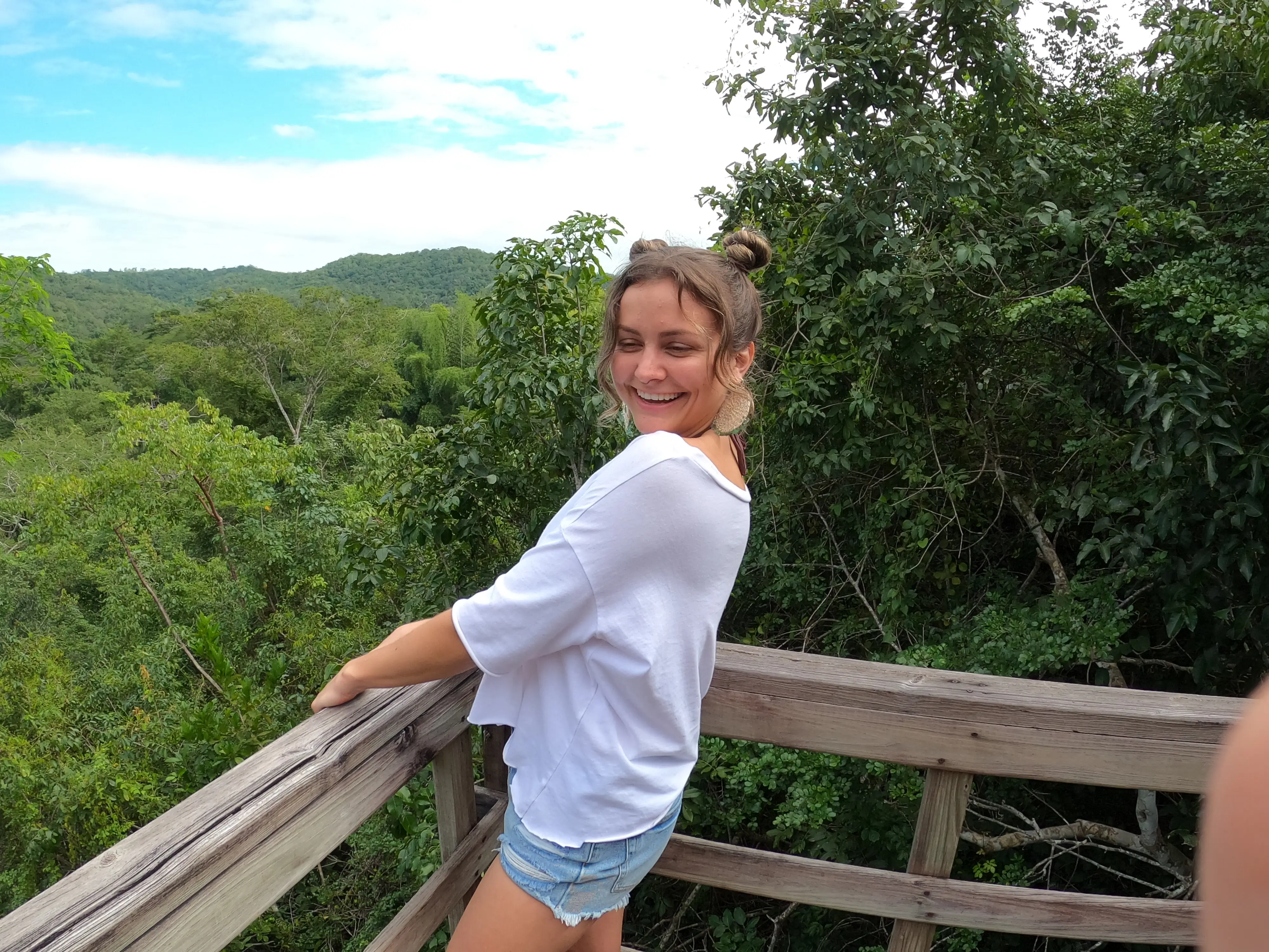 Author Melanie Gordon smiling with trees behind her