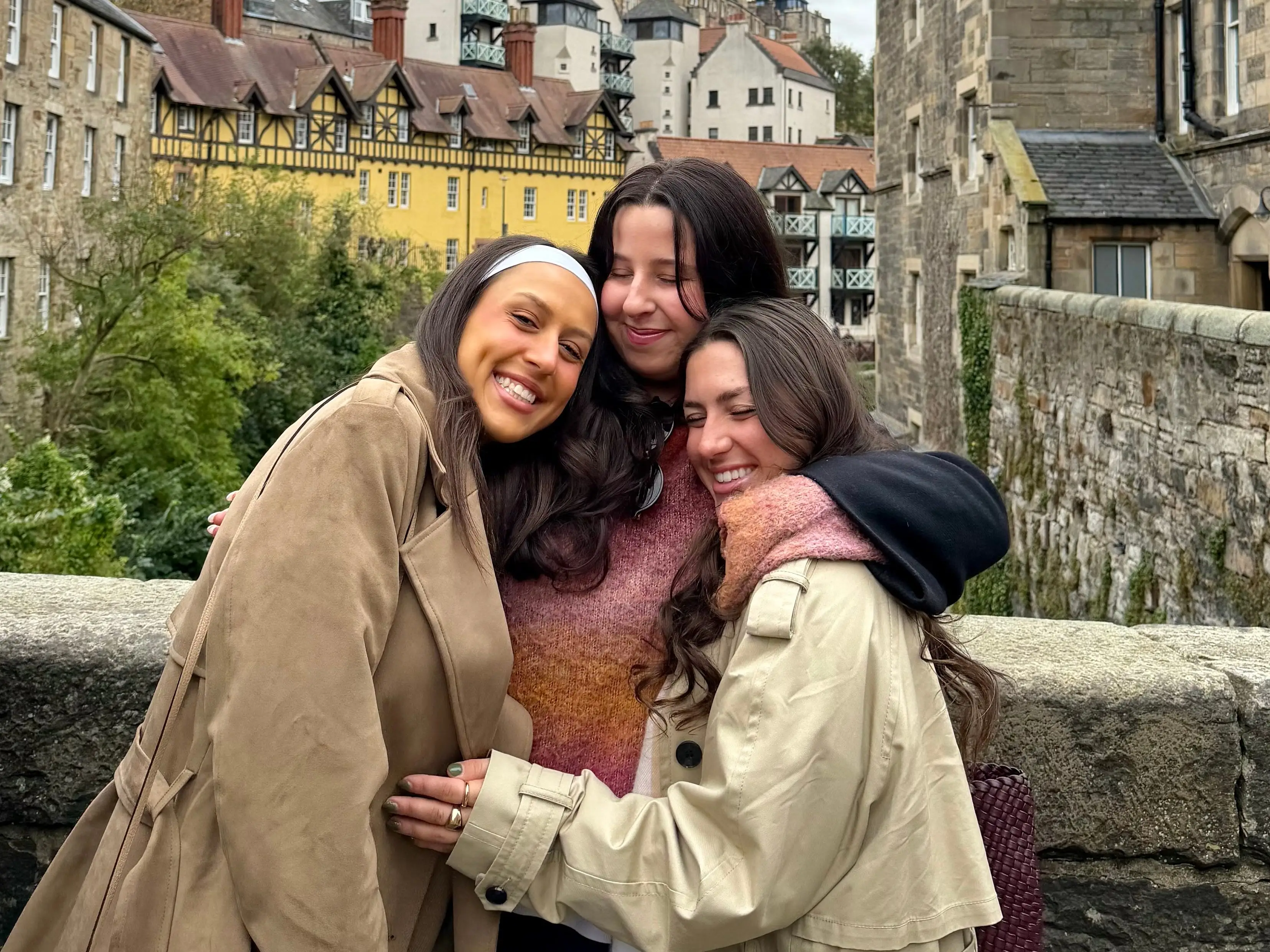 Three girls hugging at Dean's Village in Edinburgh.