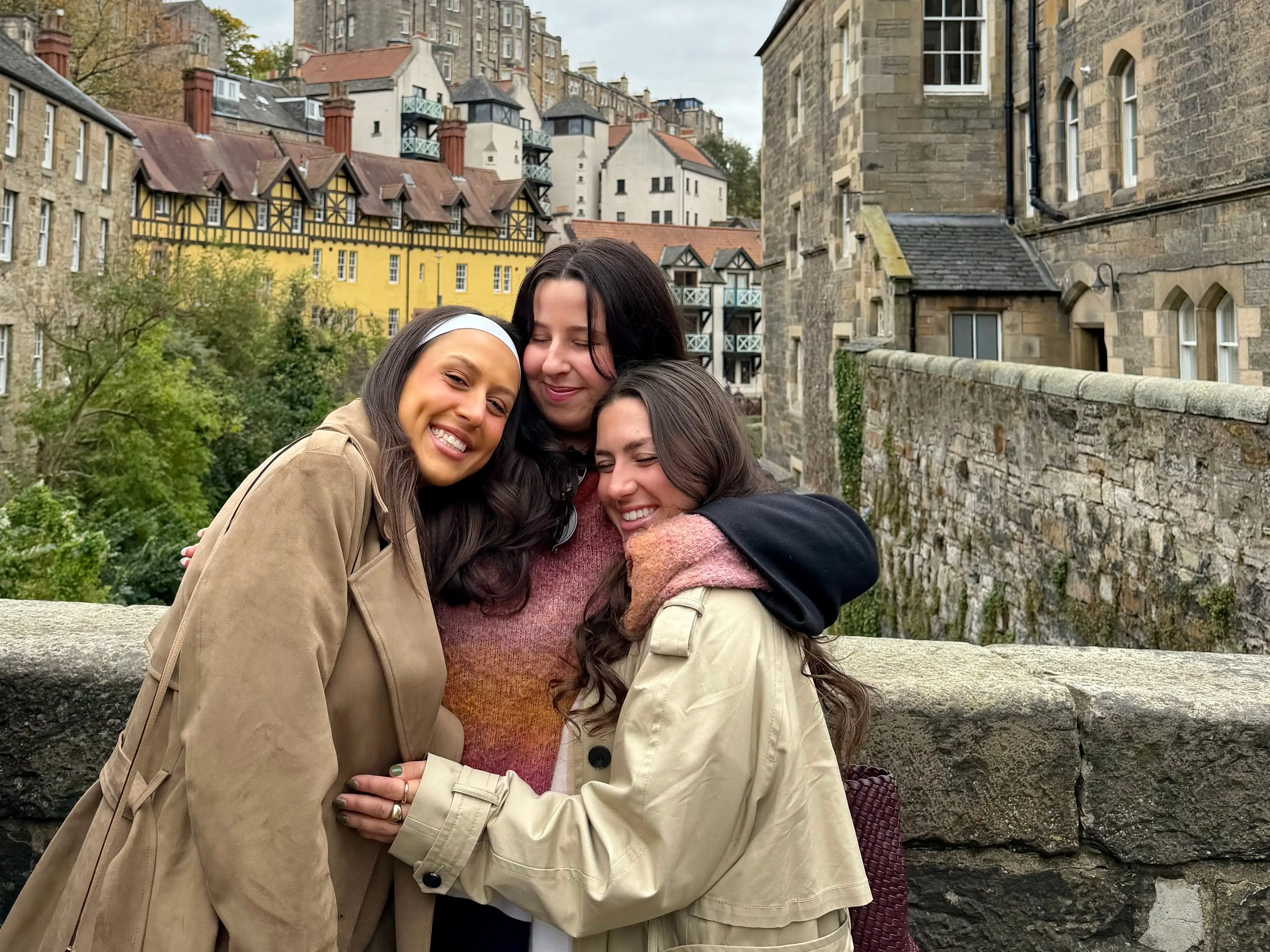 Three girls hugging at Dean's Village in Edinburgh.