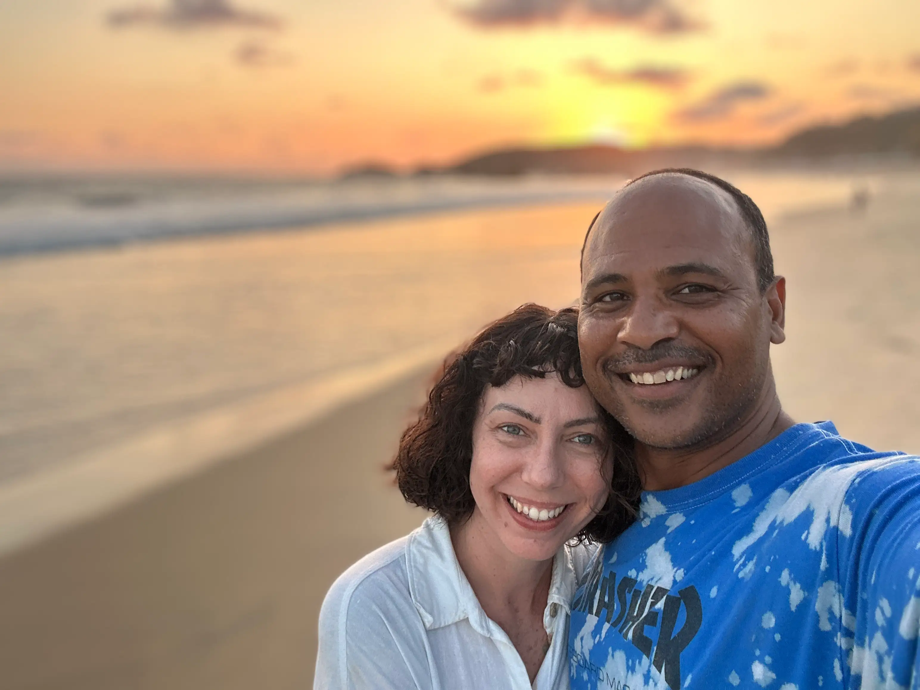 Author Lauren Qunn smiling in selfie with man on beach